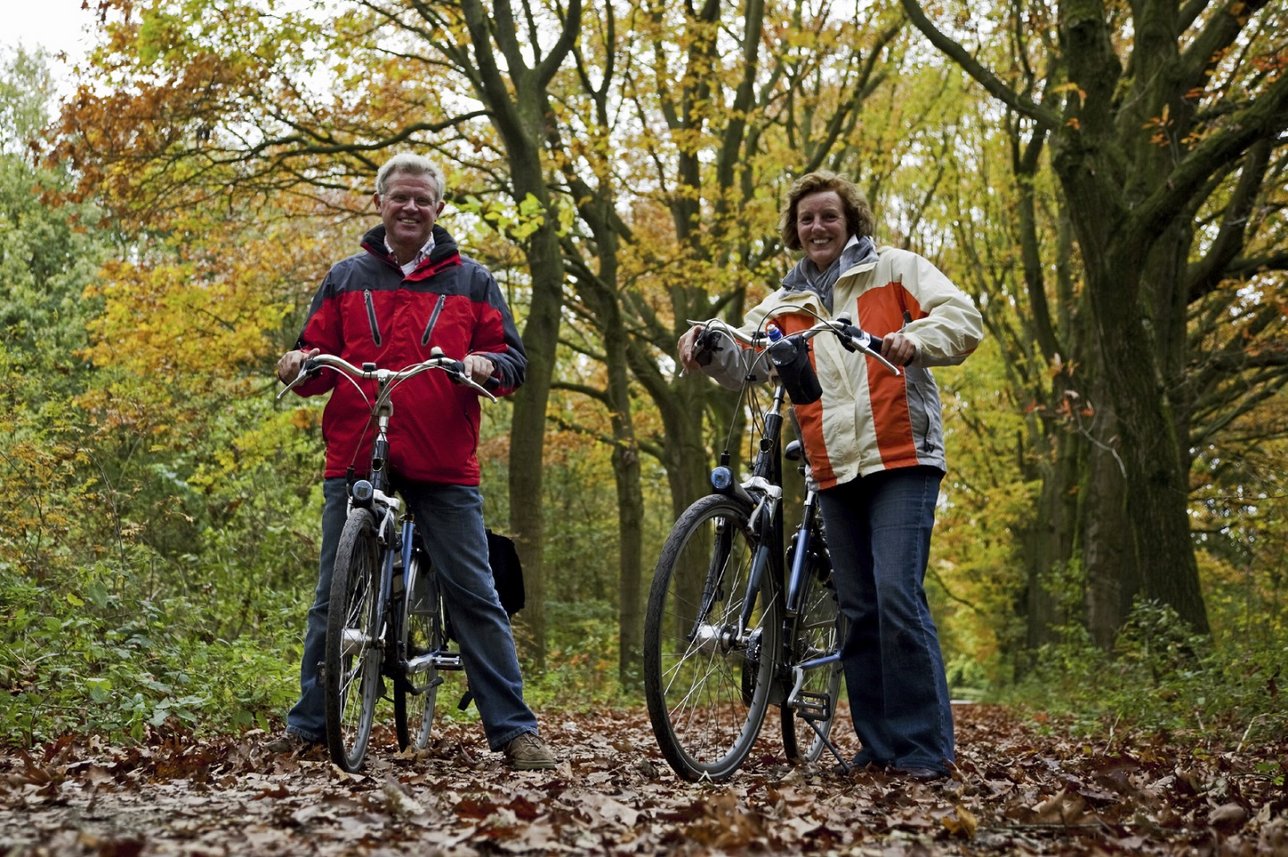 Pärchen, das im Wald Fahrrad fährt