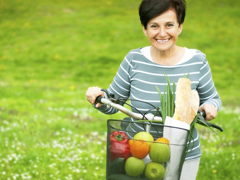 Woman on a bike with healthy food in the basket